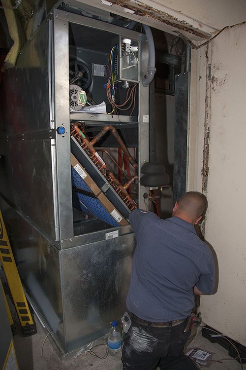 Sean McCutcheon's service technician repairing an air conditioning unit.